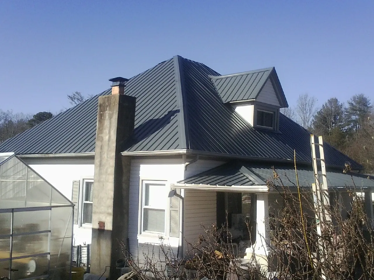 Dark blue standing seam metal roof on a white farmhouse with dormer — Slate & Tile Roof Repair by Roofing Brothers in Steeles Tavern