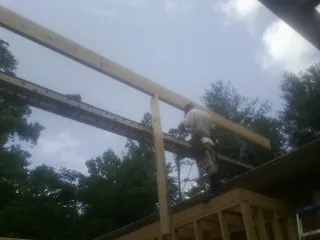 Carpenter setting a ridge beam over a new addition frame — Ice Dam Removal by Roofing Brothers in Steeles Tavern