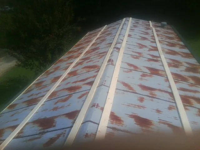 Rusted metal roof panels with new wood purlins before replacement — Storm Damage Roof Repair in Steeles Tavern by Roofing Brothers