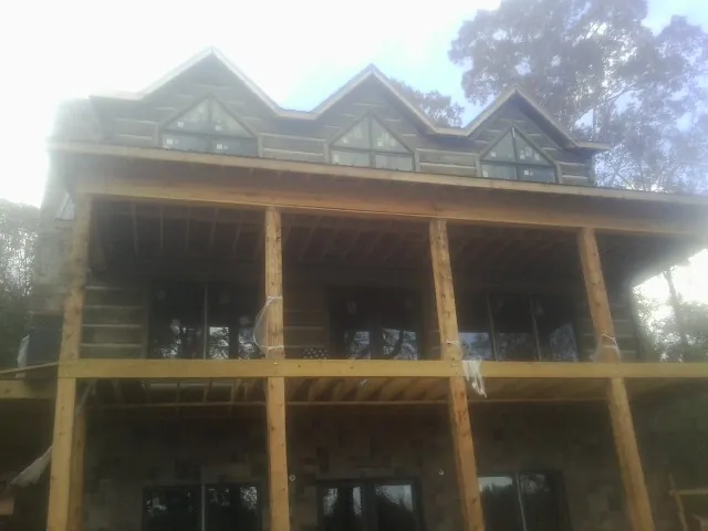 Dormers and porch framing on a large log home under construction — Roof Coating work by our crew in Steeles Tavern