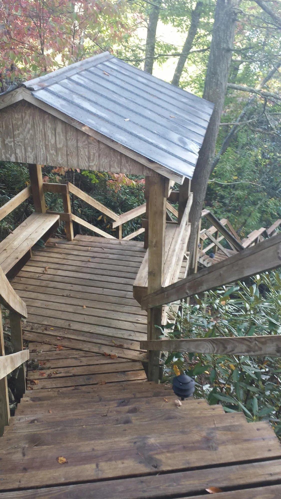 Metal roofed shelter over wooden steps on a wooded walkway — Skylight Repair & Installation work by our crew in Steeles Tavern