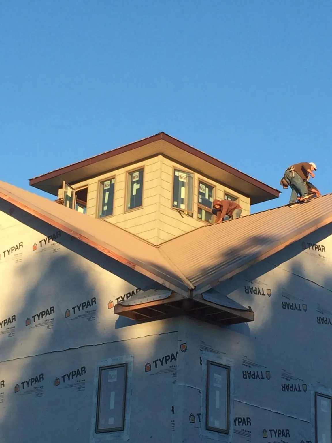 Roofers working around a rooftop cupola on a new metal roof at sunset — Roof Waterproofing in Steeles Tavern by Roofing Brothers